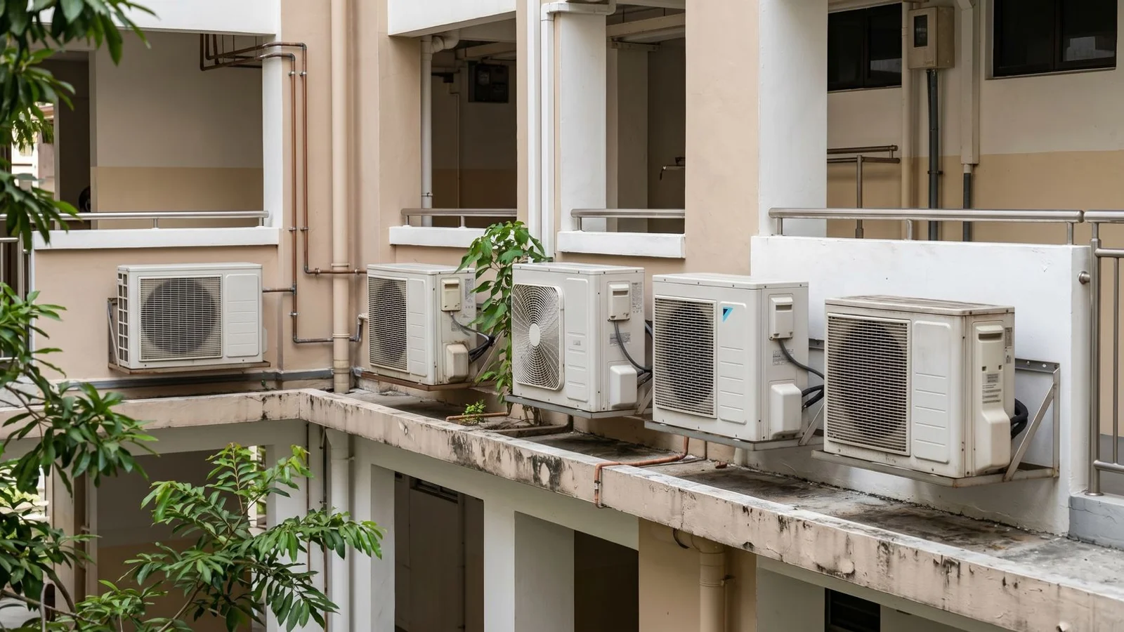 Five aircon outdoor units side-by-side with brand logos faded, daylight